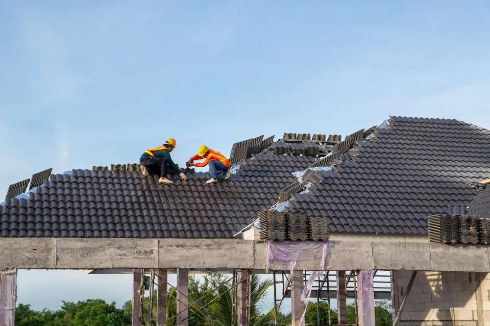 Two Crown Roofing & Waterproofing crew members working on a tile roof in Lee County, FL. 