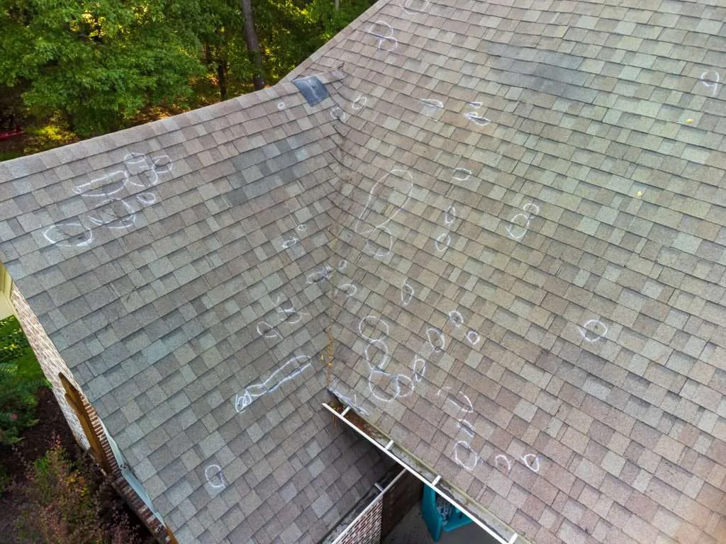 Roof hail damage with marked spots where repairs are needed.