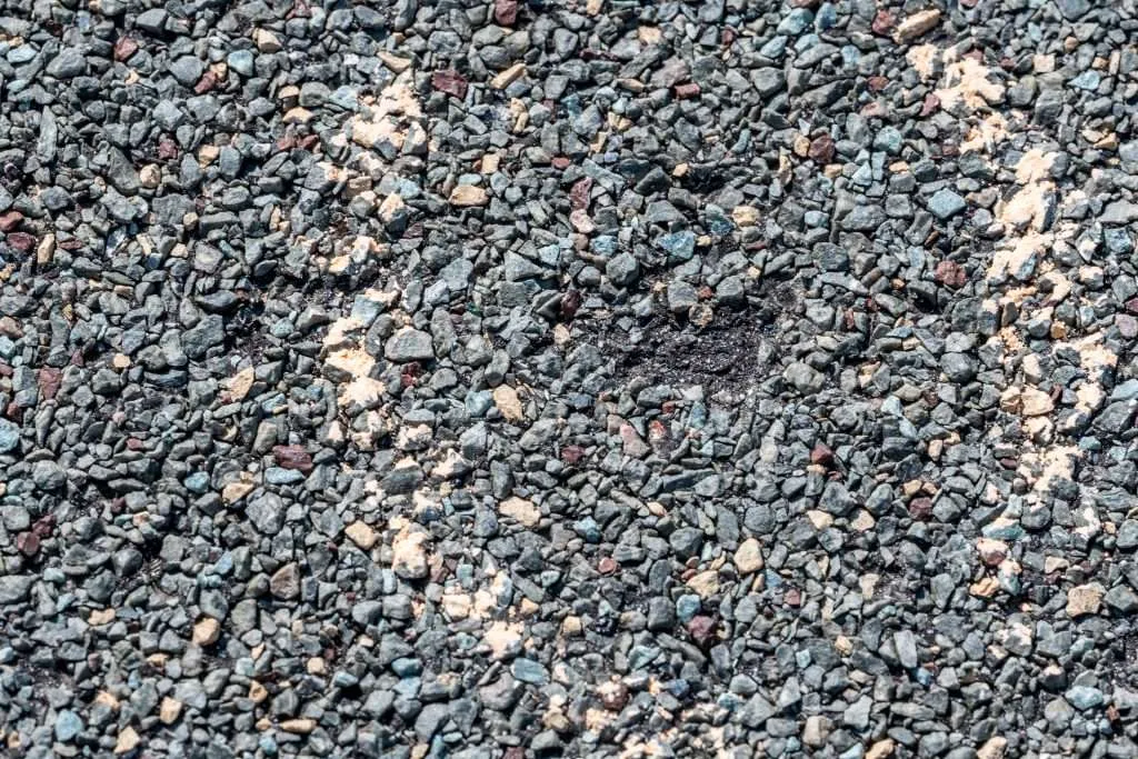 Close up of hail damage on a shingle residential roof circled with a chalk outline during a home inspection.