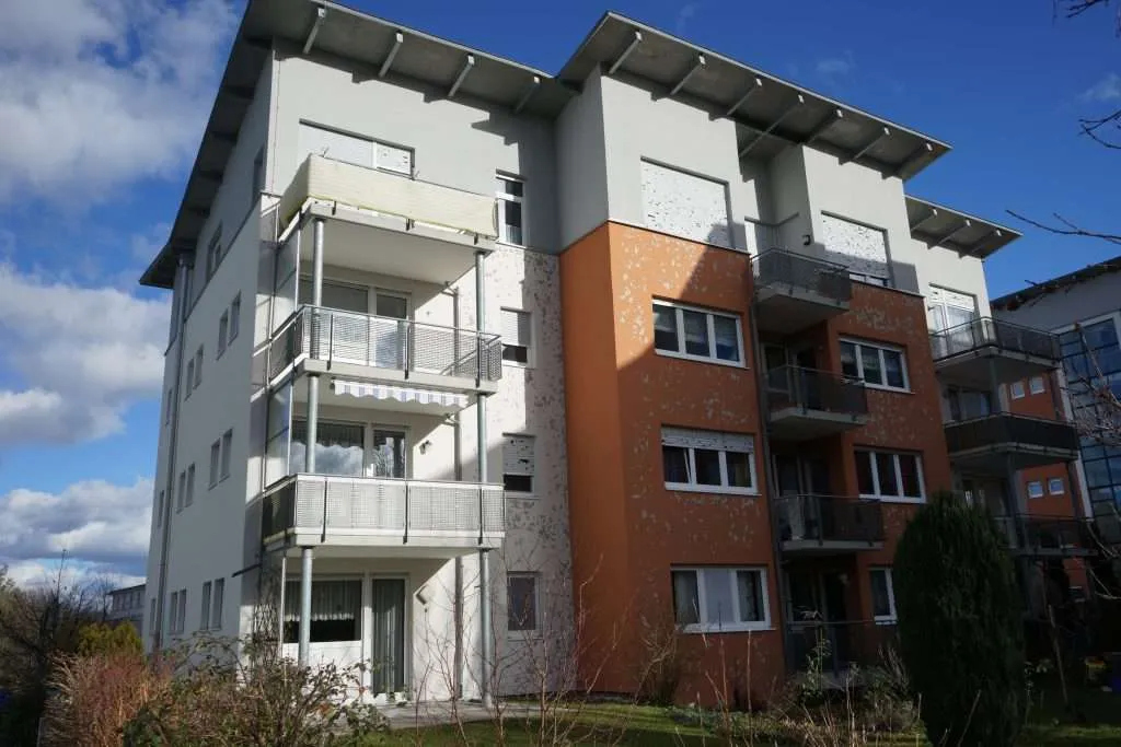Apartment building shows signs of hail damage on exterior walls and window shutters.